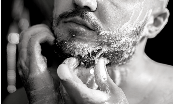 how to groom a growing beard cover image of a man cleaning his beard